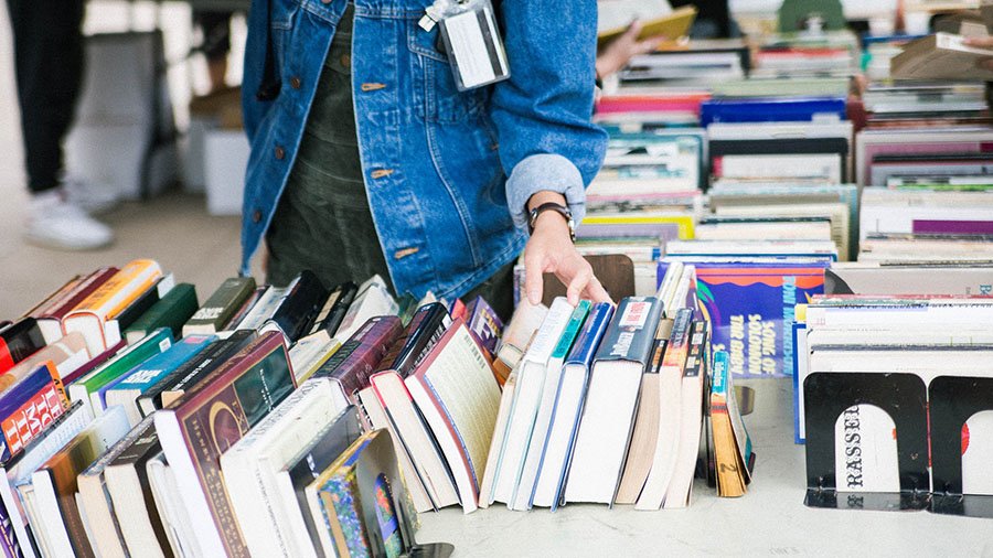 A student browses a number of books during a sale.