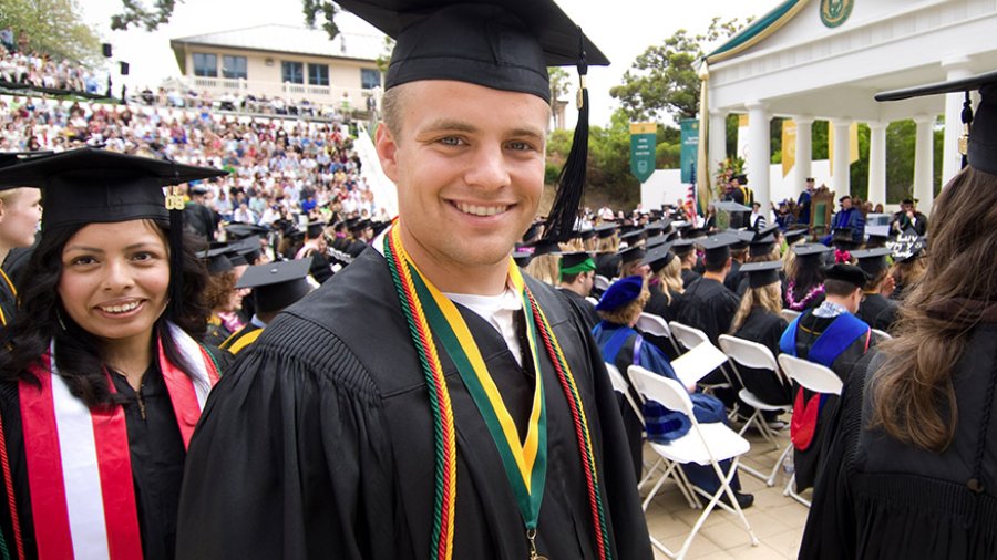 A student smiles as he gets ready to receive his diploma