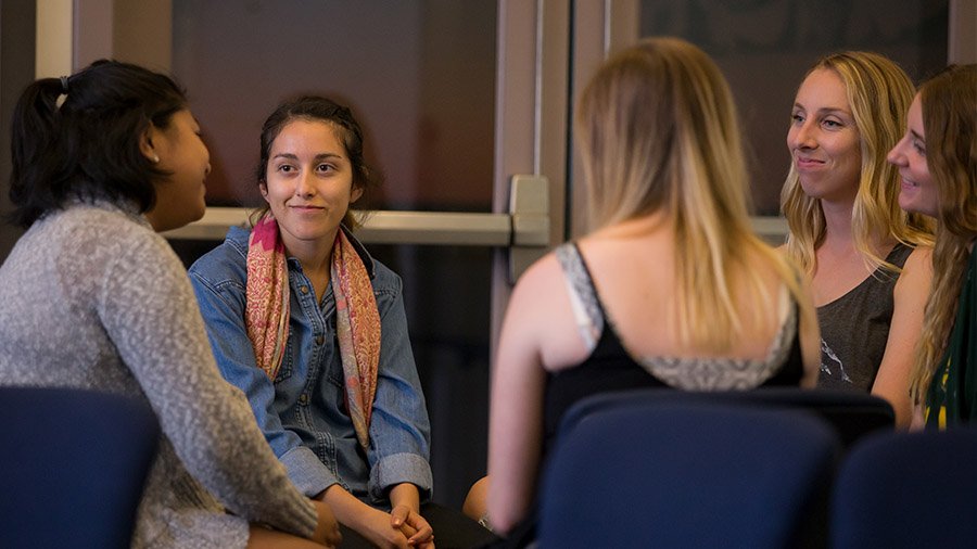 A group of students share their faith stories during a small group meeting.