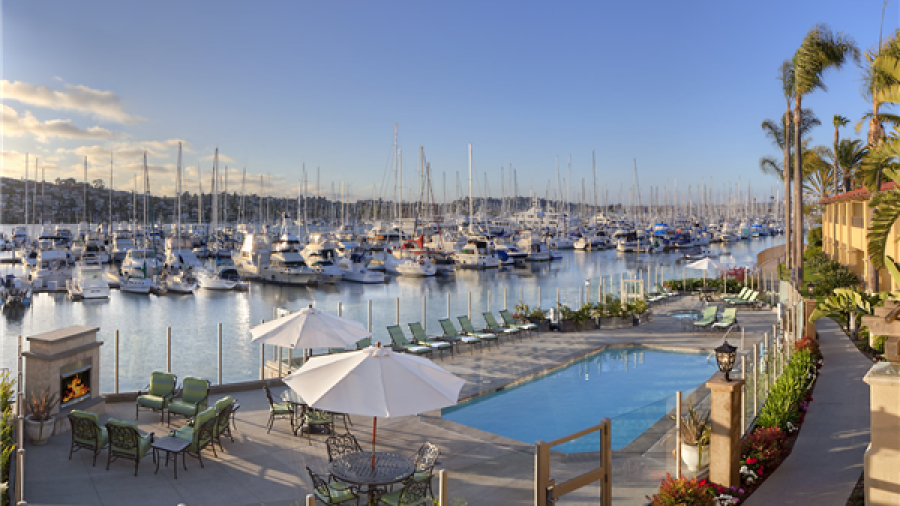 Soft light illuminates a pool overlooking a marina full of sailboats