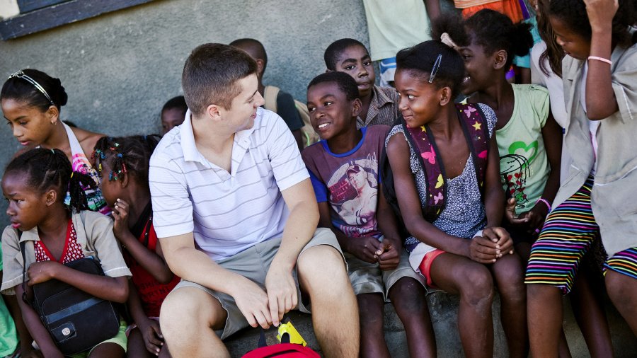 A PLNU student interacts with a group of children on a Loveworks trip in Madagascar.