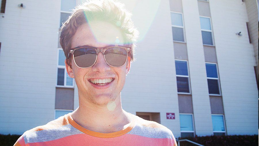 A close up portrait of a male PLNU student with sunglasses on.