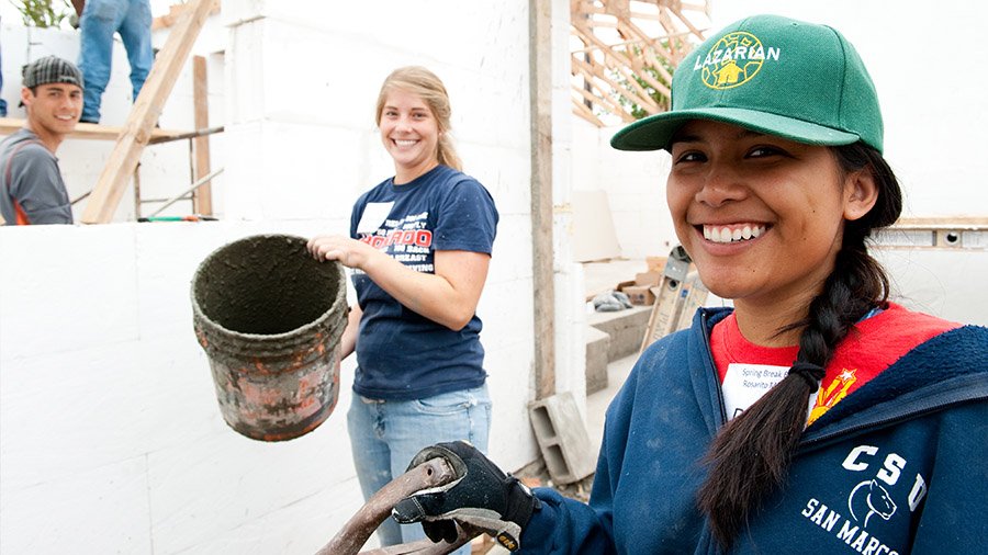 PLNU students pause to smile at the camera as they work on a construction project in Mexico.