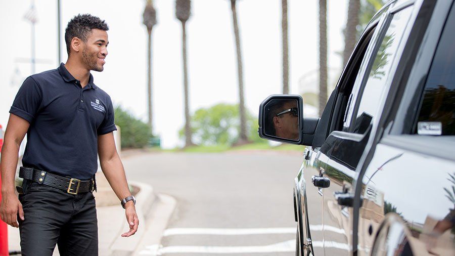 A PLNU public safety officer greets an incoming vehicle on campus.