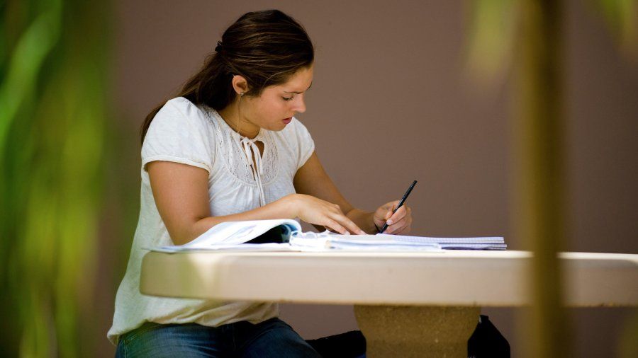A student works on an assignment outside.