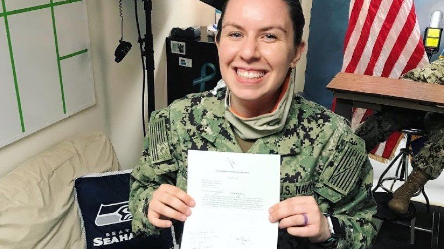 woman holding a piece of paper in her military uniform 