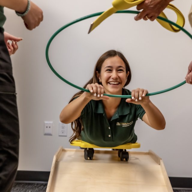 MSOT student holds onto a hoop while working on a therapy