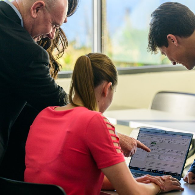 Students in the finance and investment club looking at a computer