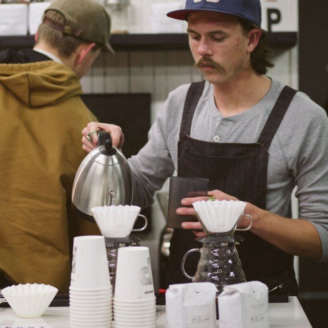 Student pouring coffee at a Brewed Awakening event.