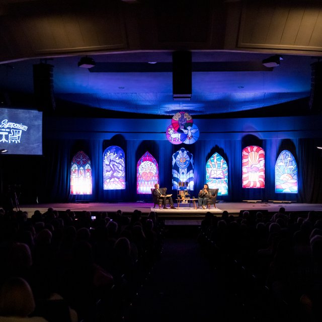 Image of Professor Dean Nelson with Sandra Cisneros for their interview with the Writer's Symposium on the stage in Brown Chapel.
