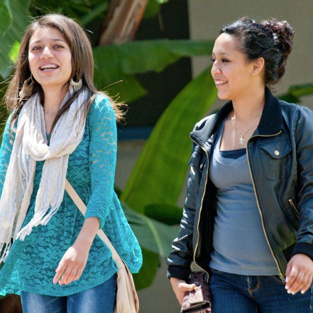 Two female students talking while walking to the class