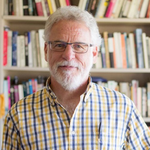 Dr. Karl Martin, professor of literature, sits in his office.