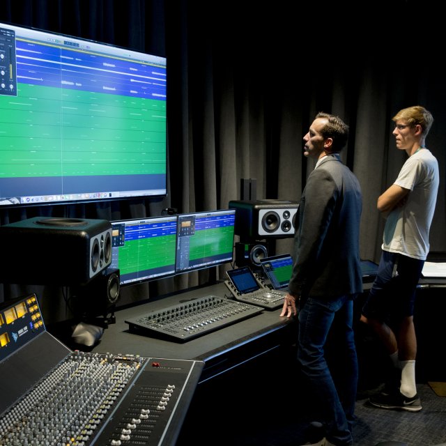 Faculty member and student review an audio production project together in PLNU's recording studio.