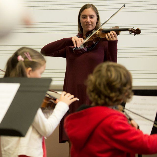 A student teaches children violin through the Point Loma String Project