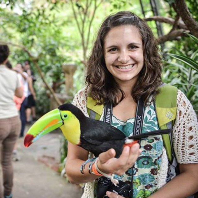 Student holds a Toucan while studying abroad