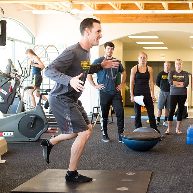 Professor Jeff Sullivan balances on one leg as he gives a class demonstration in the Athletic Training Center