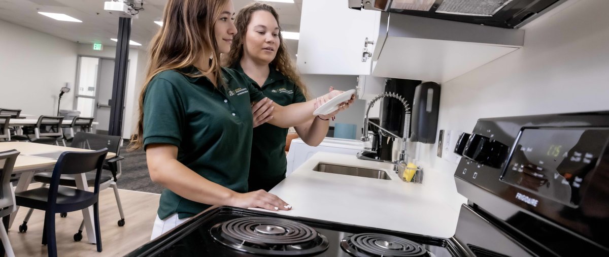 MS-OT student trains for her career by helping a person in a kitchen