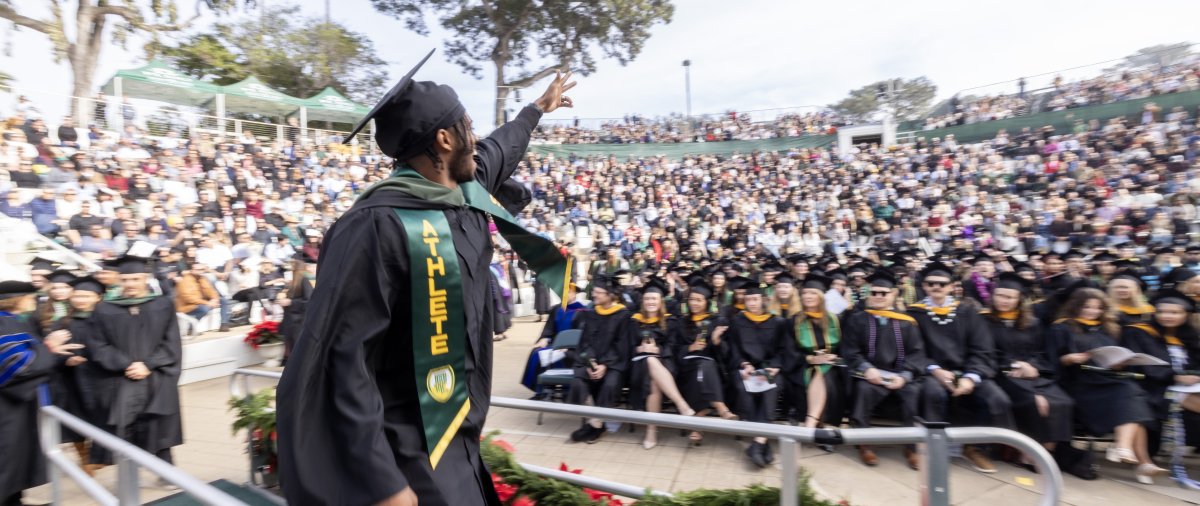 PLNU student celebrating at their commencement ceremony to receive degree.