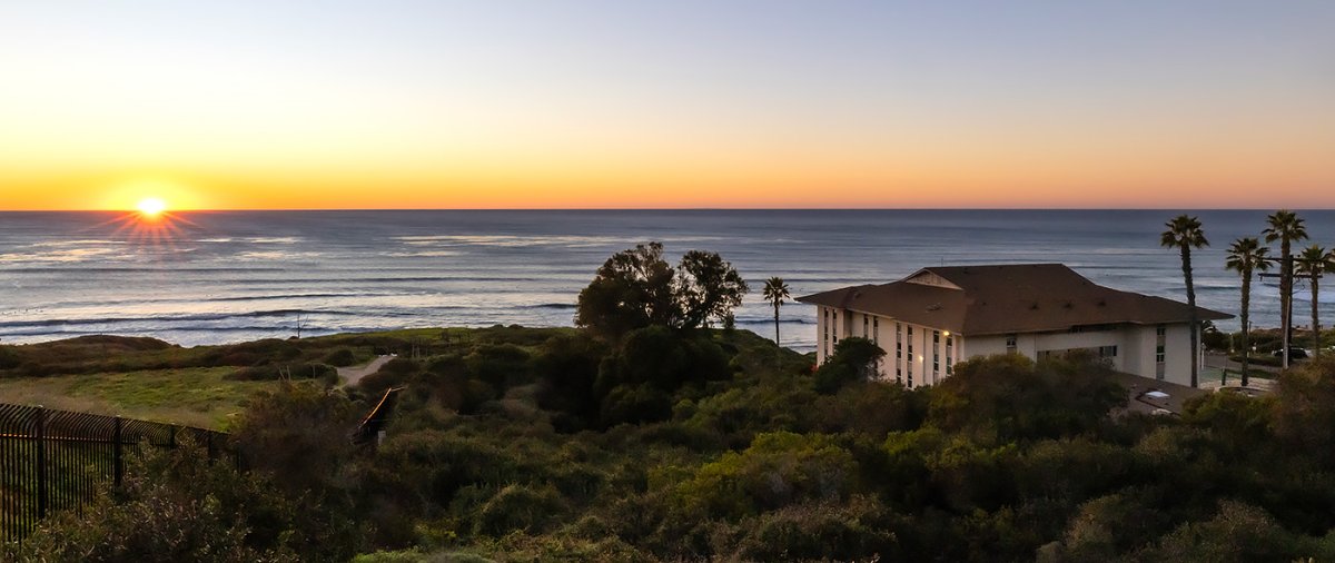 Sunset along Pacific Ocean horizon with Young Hall in shot.