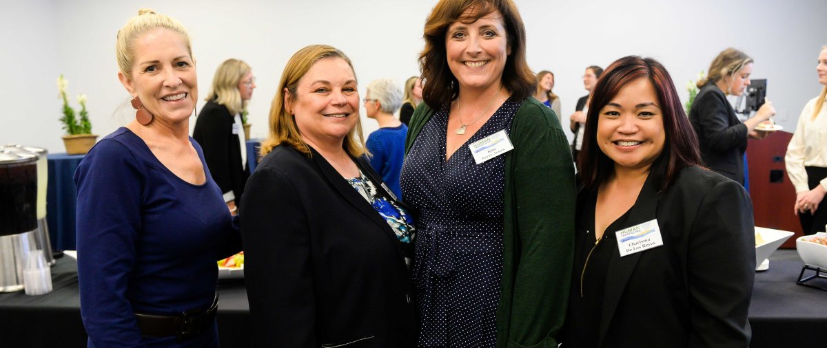 Group of women business leaders stand together for a photo
