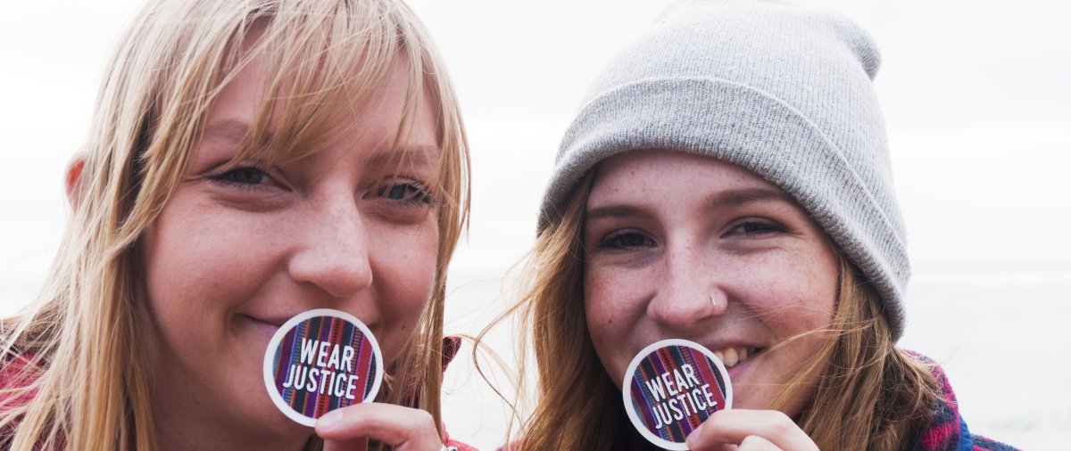 Students holding up CJR Wear Justice stickers