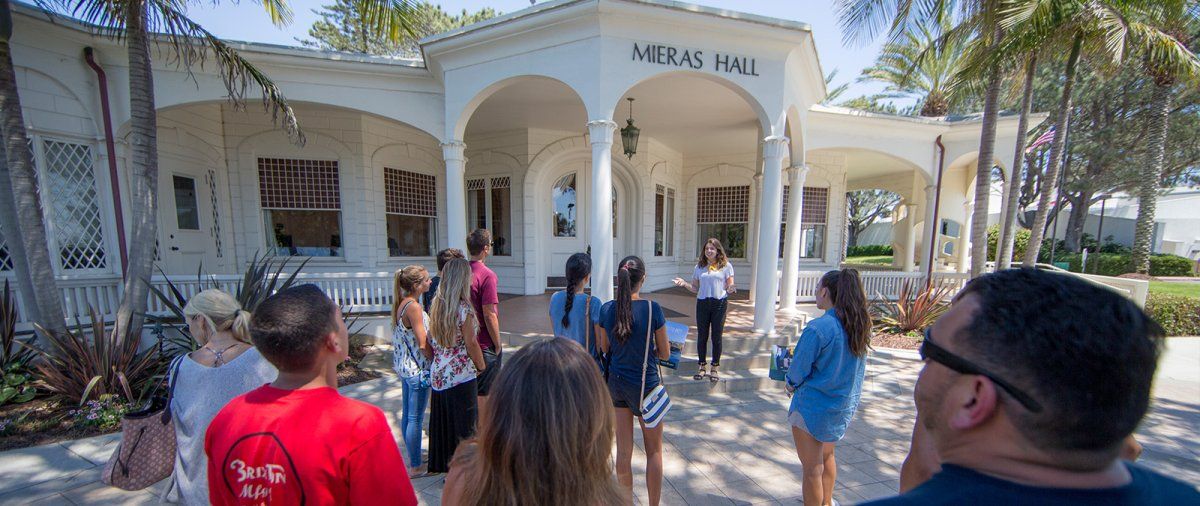 A PLNU tour guide speaks to a group in front of Mieras Hall
