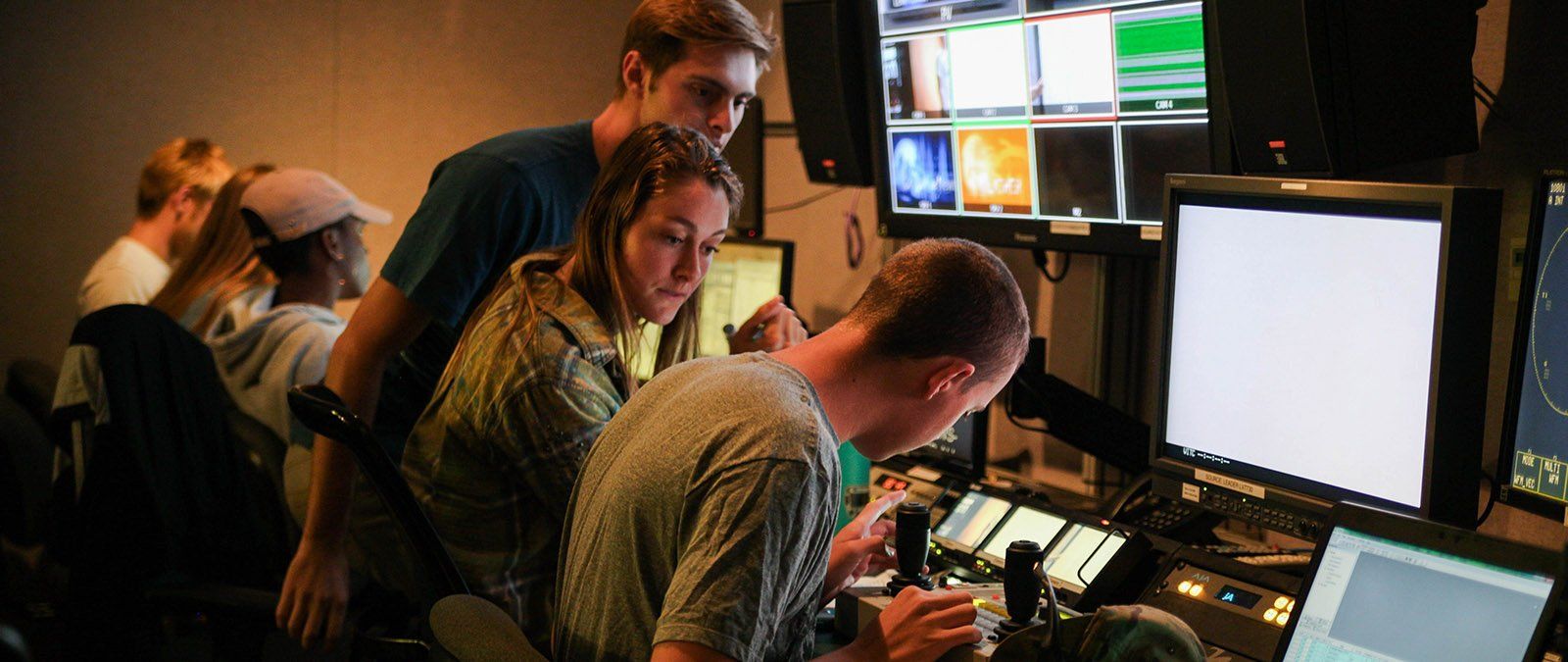 A group of Media Comm students work behind the scenes production in the PointTV studio 