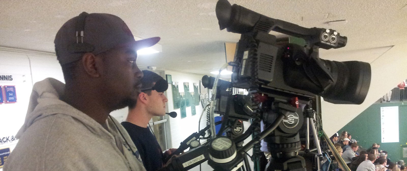 Student videographers broadcast a live stream of a PLNU basketball game from the top of the arena.