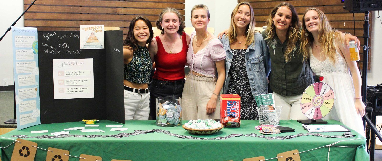 PLNU students smile for a photo at a recycling display