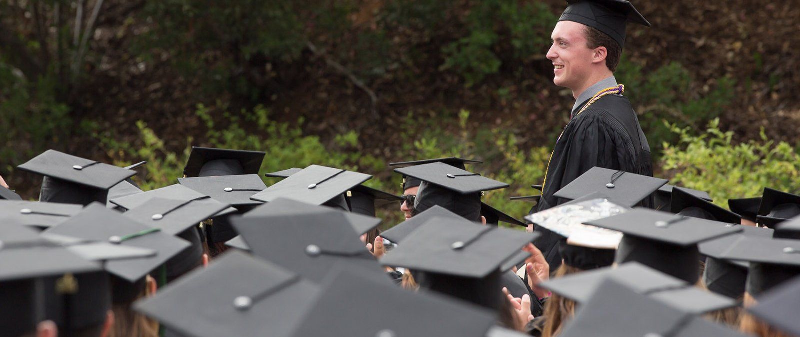 PLNU student Nick, rises to receive his diploma at PLNU's undergraduate commencement ceremony.