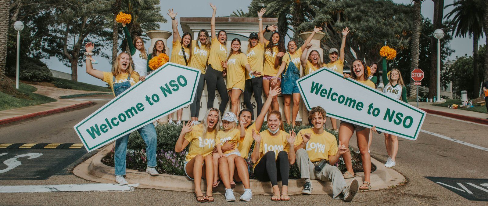 New Student Orientation volunteers excited to greet new students. Holding welcome to NSO sign