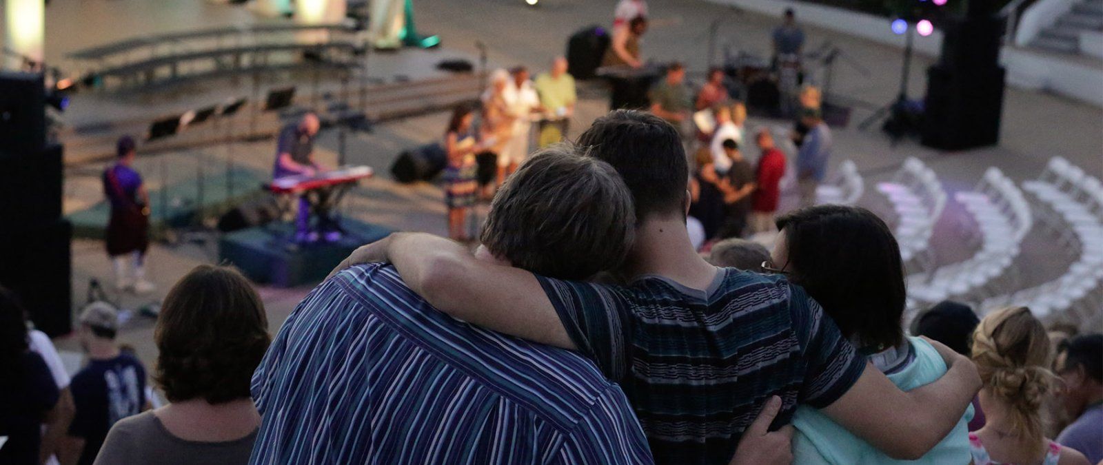 A family worships together in the Greek Amphitheatre during NSO.