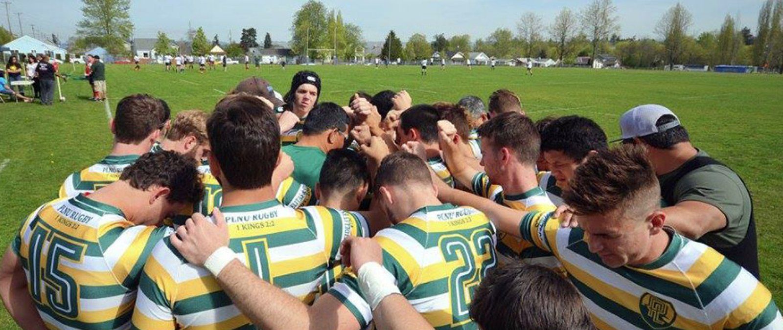 PLNU Rugby Club players gather in a huddle to pray before a match.