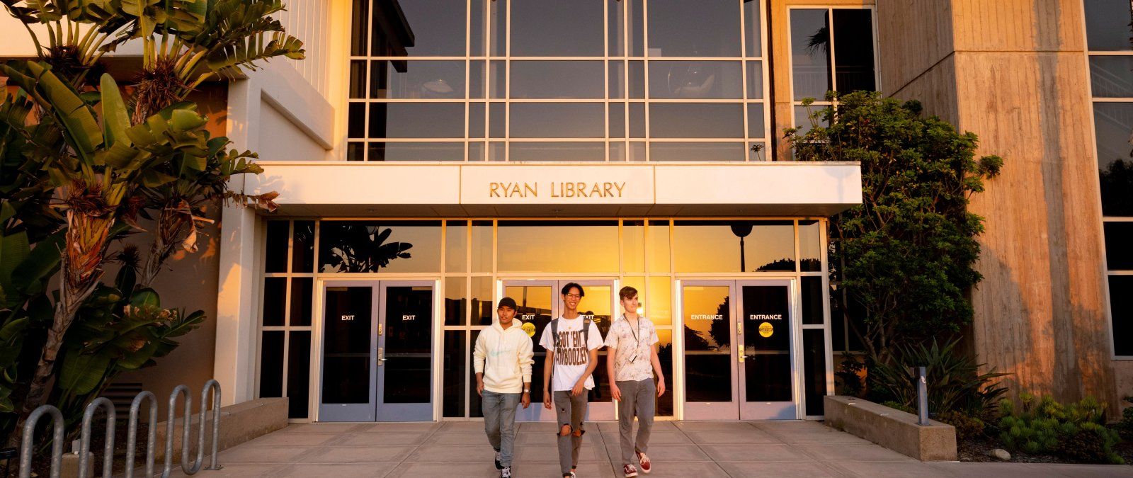 ryan library with three students standing in front 