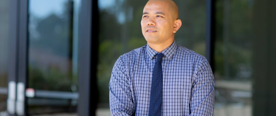 A man in a business attire steps outside after a meeting.