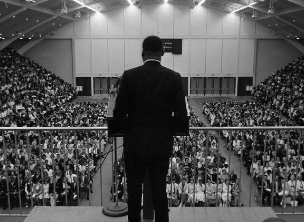 Martin Luther King Jr speaks to a large crowd gathered in Golden Gymnasium.