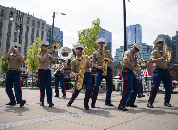 7 musicians playing various brass instruments with movement