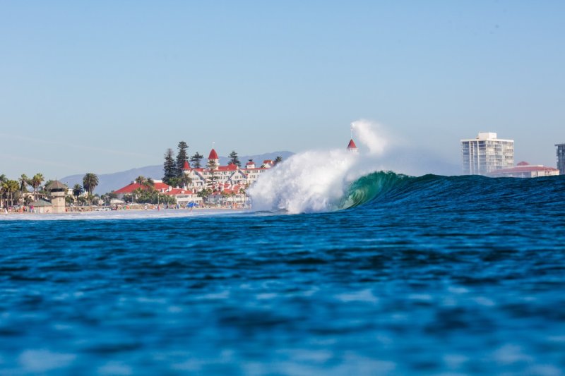 A wave crashing into the shore in front of the Hotel Del in Coronado.