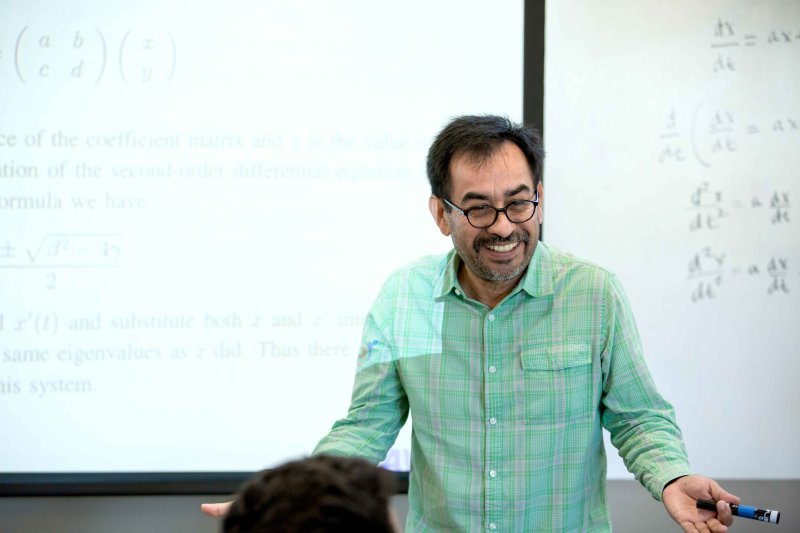 A professor lectures in front of his classroom