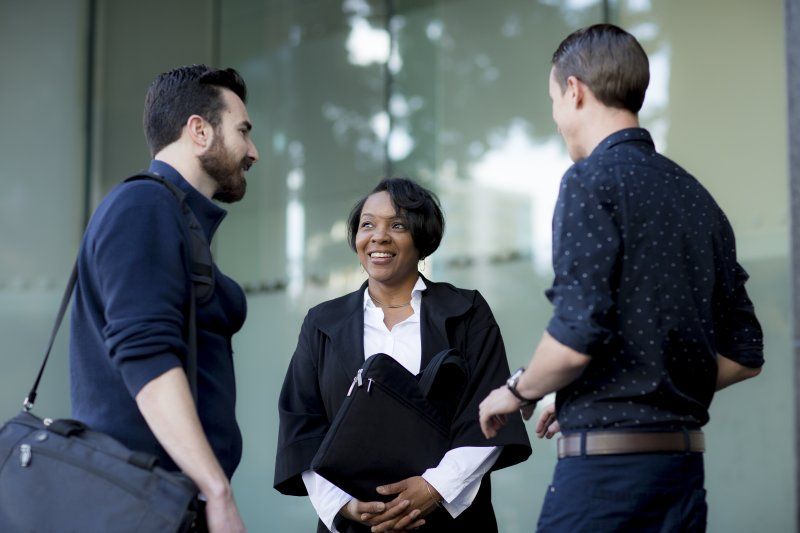 an african american woman talking to two men 