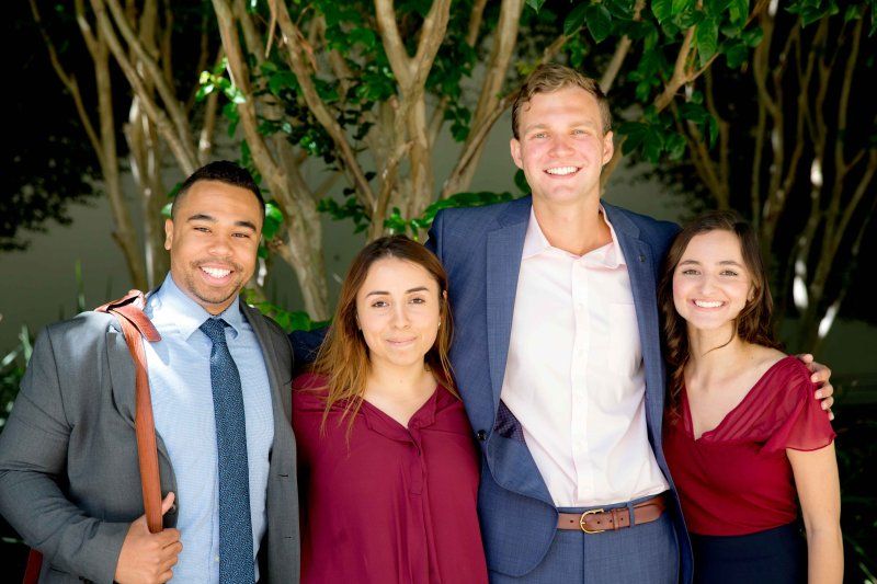 Group of PLNU business students gather together for a photo