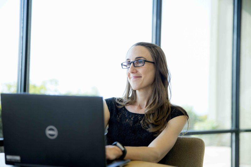 PLNU student looks up from work on her laptop