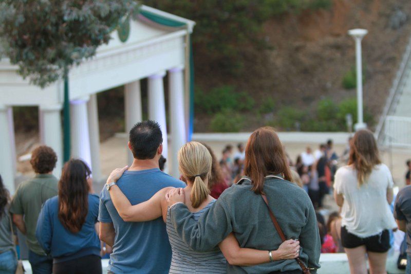 A family hugs at a PLNU service in the Greek.