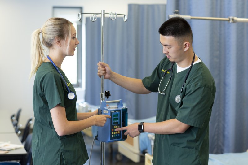 Two PLNU nursing students working in university medical labs using field's technology for assessment.