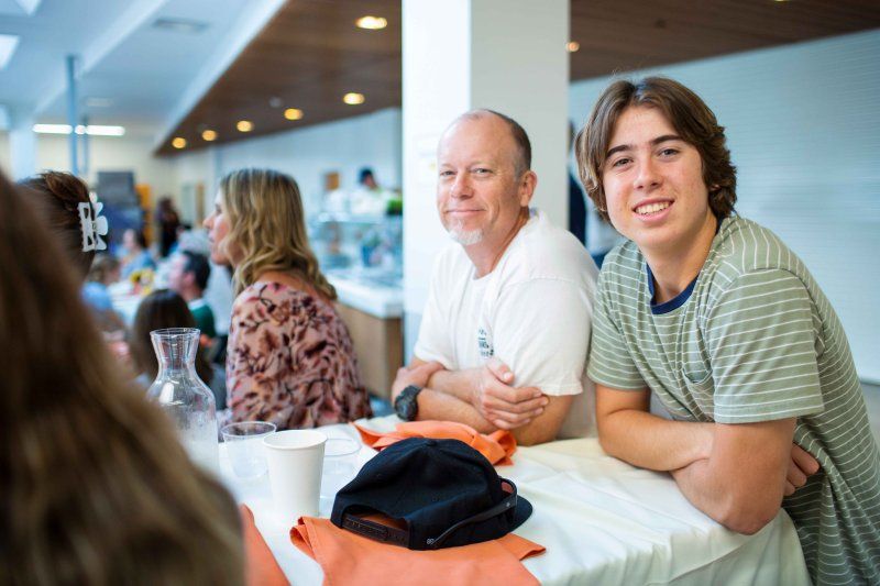 Father and son smile at a PLNU event