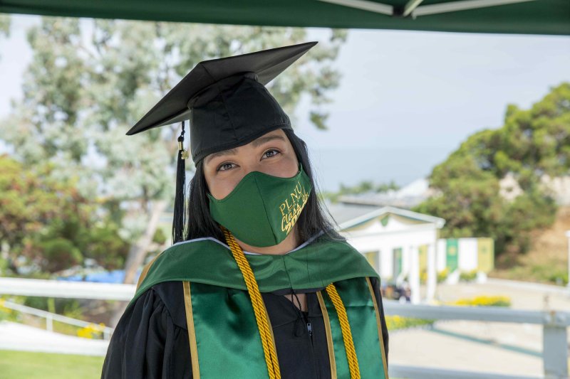 A masked student at PLNU's graduation ceremony