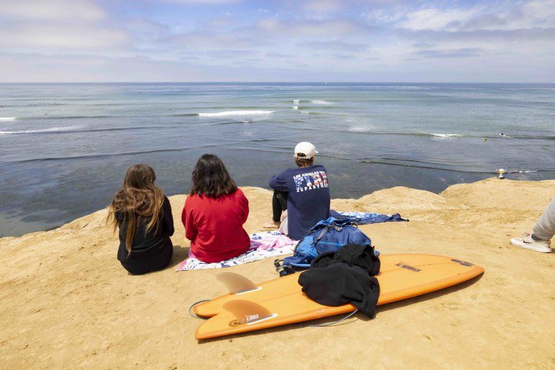 PLNU students watch surfers from Sunset Cliffs