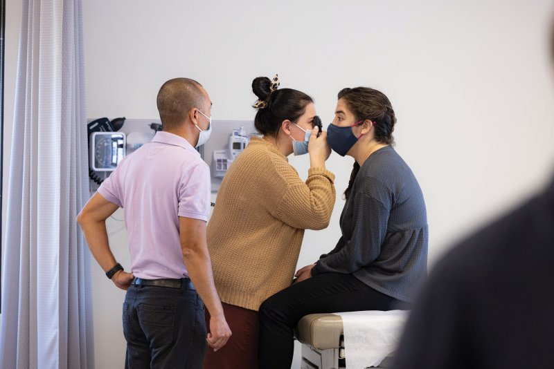 A PA student performs an eye exam