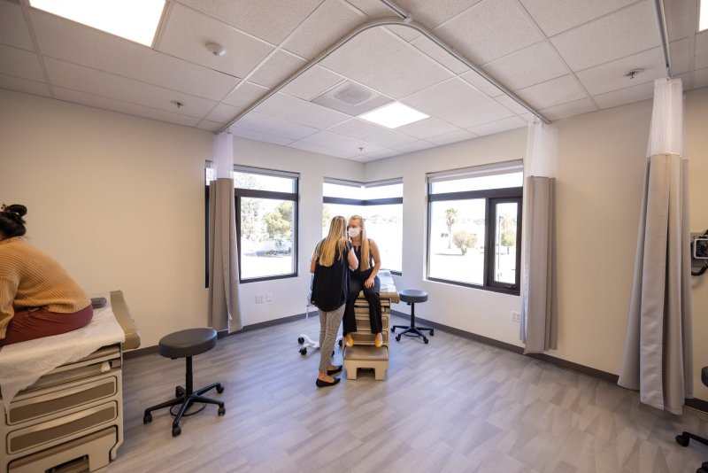 A PA student exams a patient at the Balboa Campus