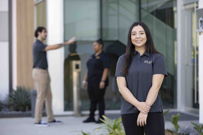 Female PLNU grad student smiles in front of the Balboa Campus
